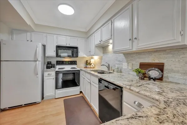 a kitchen with granite countertop a refrigerator stove and microwave