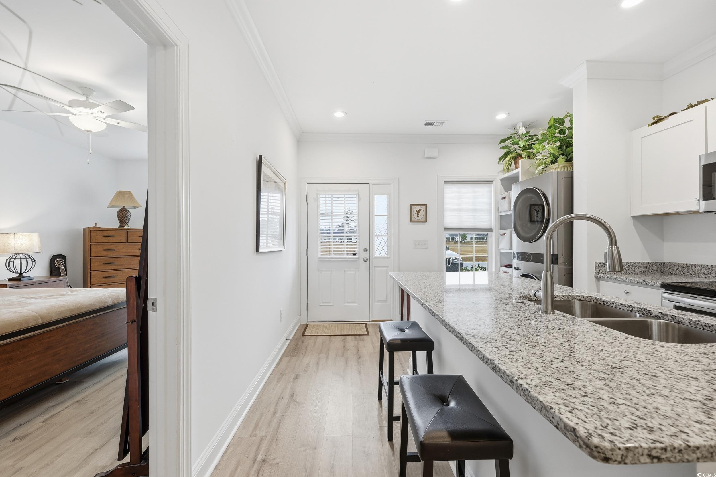 116 Kingsbury Loop, Unit C Conway, SC 29526 - Photo 7 of 32 Kitchen featuring light stone counters, ornamental molding, white cabinetry, a kitchen bar, and lvp floors