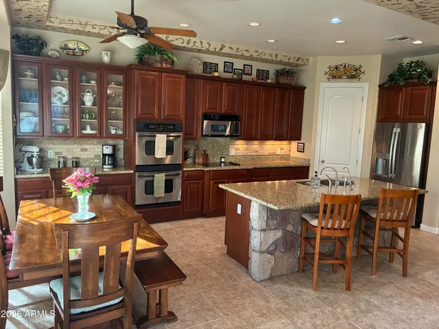 a kitchen with stainless steel appliances granite countertop a sink a stove top oven a counter space and cabinets