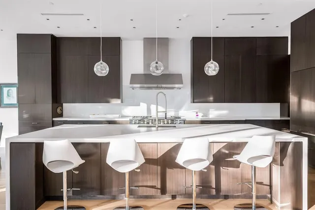 a kitchen with a dining table chairs cabinets and stainless steel appliances