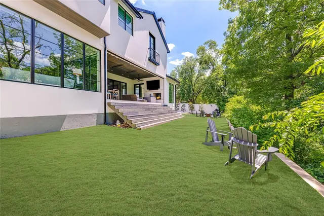 a view of an house with backyard and a tree