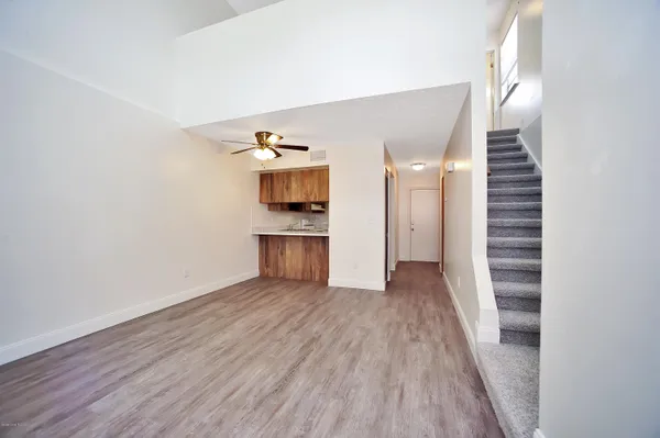 a view of a kitchen with wooden floor and a hallway