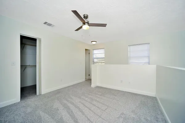 a view of a livingroom with a ceiling fan & entryway