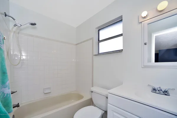a bathroom with a bathtub shower sink vanity and toilet
