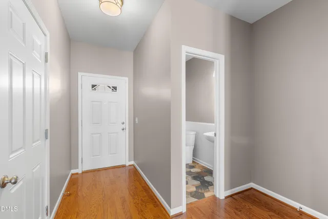 a view of hallway with bathroom and wooden floor