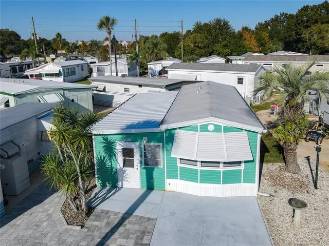 a view of a house with a yard and potted plants
