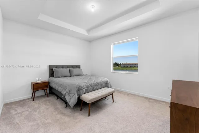 a spacious bedroom with a bed and a lamp on table