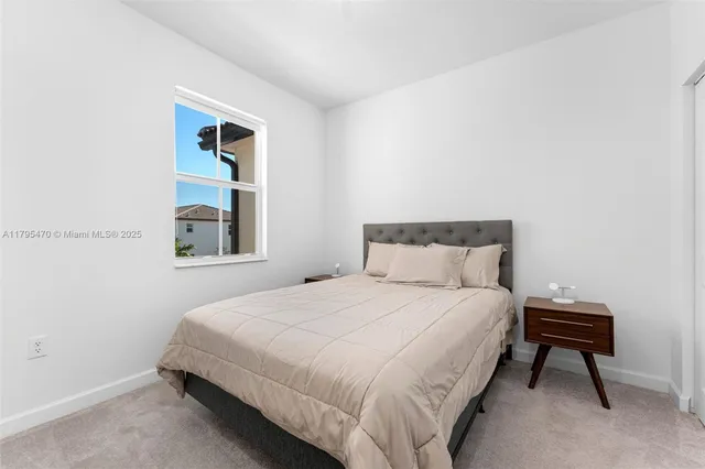 a bedroom with a bed table and a window