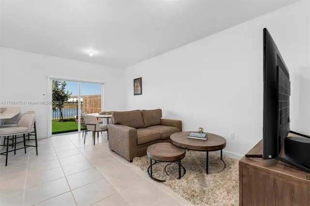 a living room with furniture a flat screen tv and a table