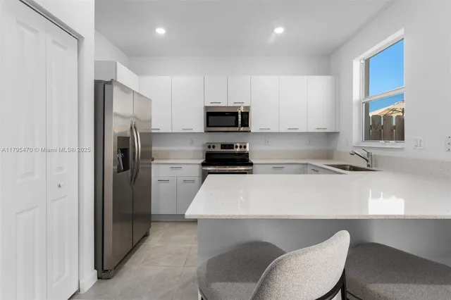 a kitchen with a refrigerator a stove a sink and a cabinets