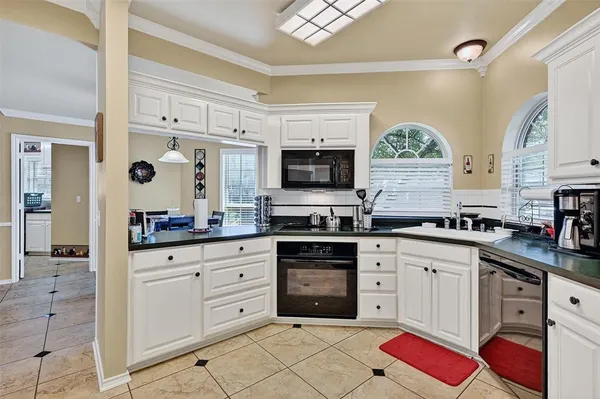 a kitchen with stainless steel appliances granite countertop a sink and cabinets with wooden floor