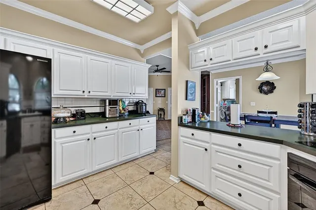 a kitchen with granite countertop white cabinets and stainless steel appliances