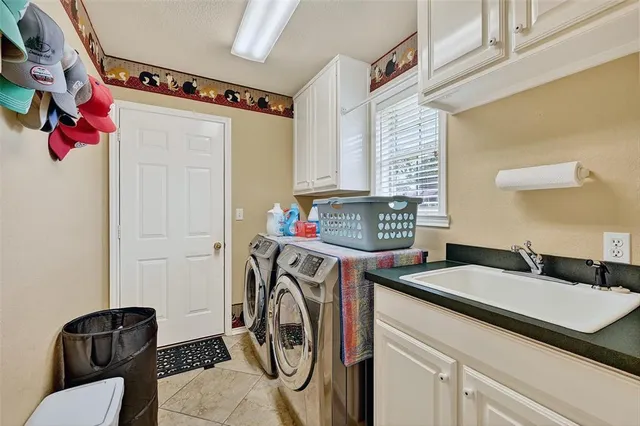 a utility room with sink dryer and washer