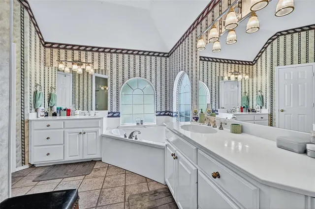 a spacious bathroom with a double vanity sink a mirror and a bathtub