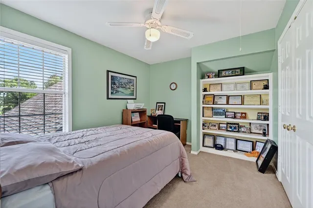 a bedroom with a bed a book shelf and a window