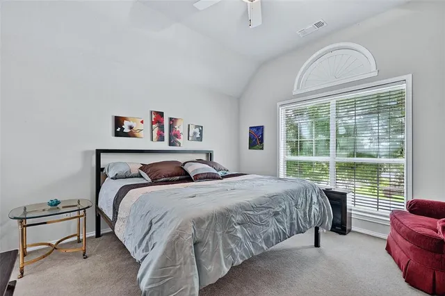 a bedroom with a bed and a large window