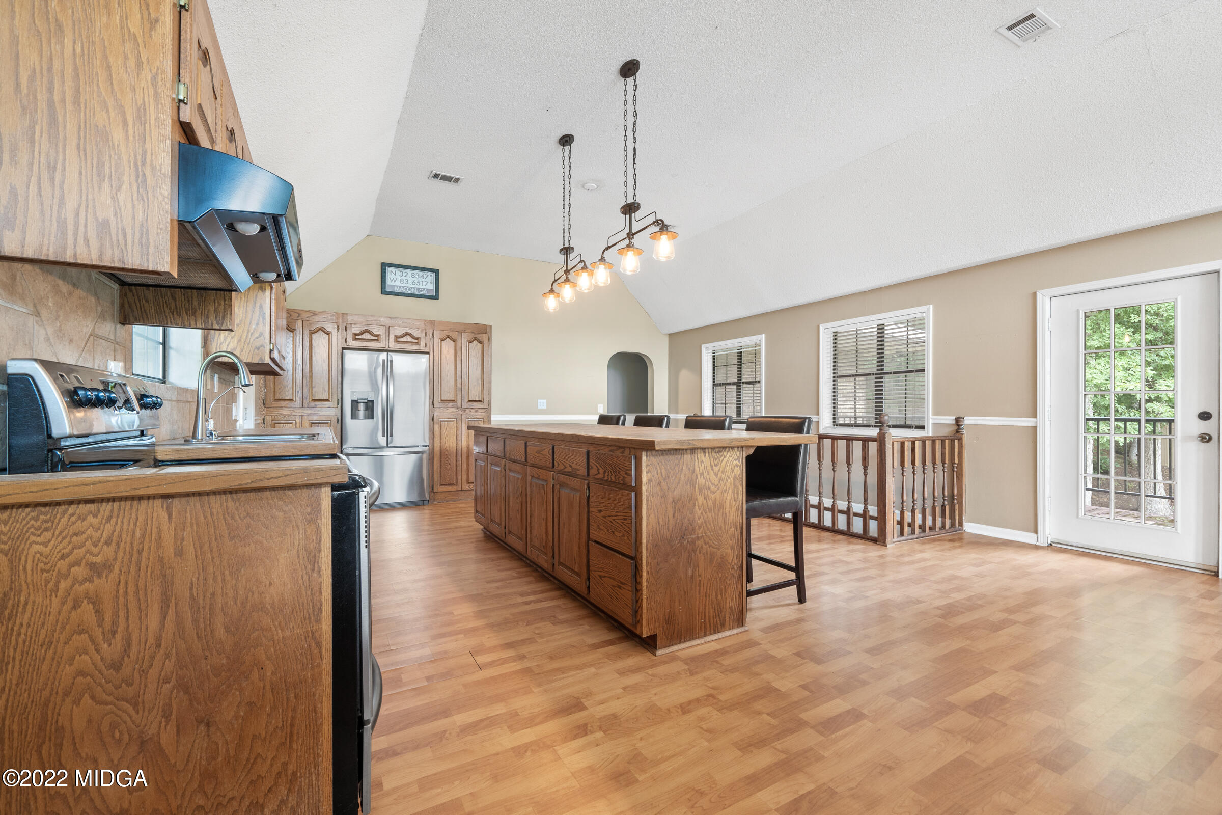 457 Lite-N-Tie Road Gray, GA 31032 - Photo 5 of 30 a open kitchen with stainless steel appliances granite countertop a refrigerator a sink dishwasher a dining table and chairs with wooden floor