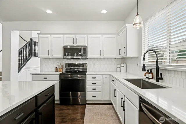 a kitchen with stainless steel appliances white cabinets and a sink