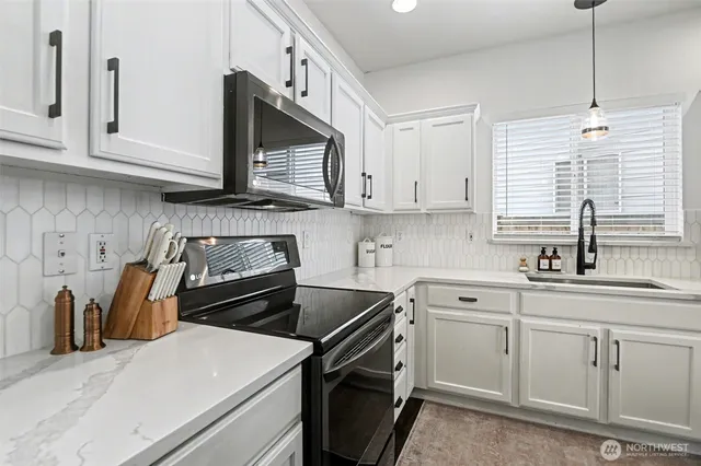 a kitchen with cabinets appliances a sink and a window