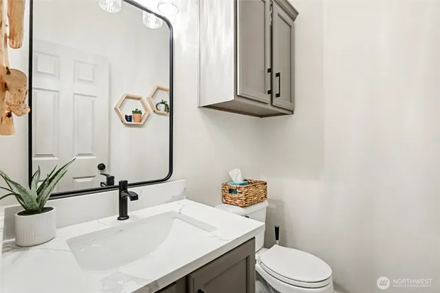 a bathroom with a sink a toilet and mirror