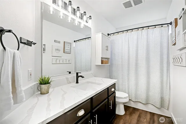 a bathroom with a granite countertop sink a toilet and a mirror