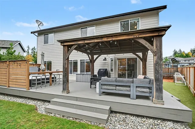 a view of a house with a wooden deck and furniture