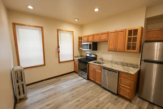 a kitchen with stainless steel appliances granite countertop a refrigerator a stove top oven a sink and dishwasher