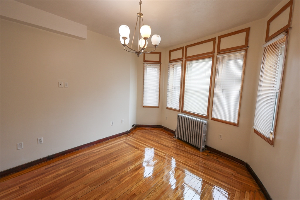 100 Seaver Street, Unit 2 Boston, MA 02121 - Photo 11 of 18 a view of an empty room with wooden floor and a window