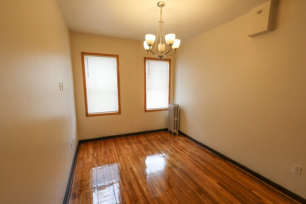 100 Seaver Street, Unit 2 Boston, MA 02121 - Photo 12 of 18 a view of an empty room with wooden floor and a window