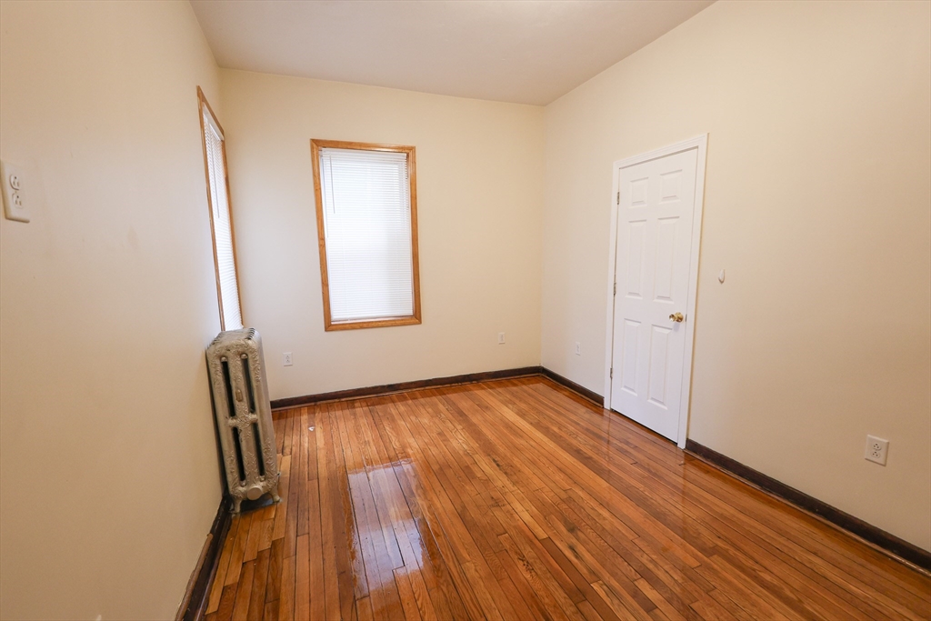 100 Seaver Street, Unit 2 Boston, MA 02121 - Photo 13 of 18 an empty room with wooden floor and windows