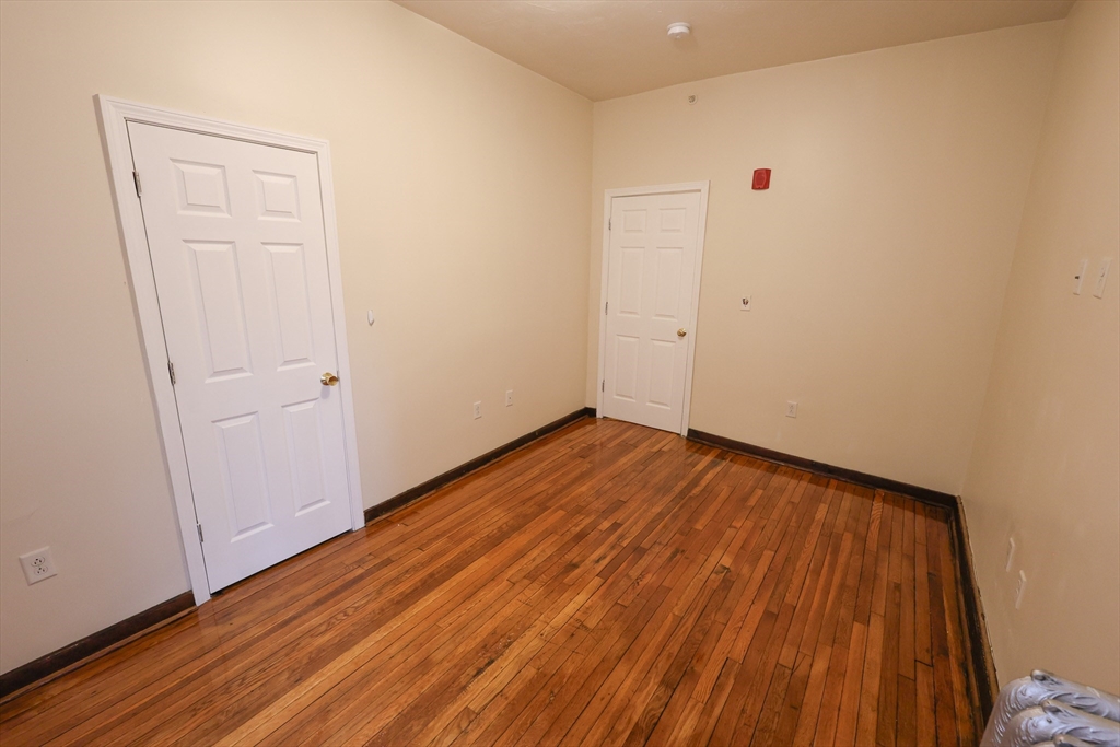 100 Seaver Street, Unit 2 Boston, MA 02121 - Photo 14 of 18 a view of a room with wooden floor and white doors
