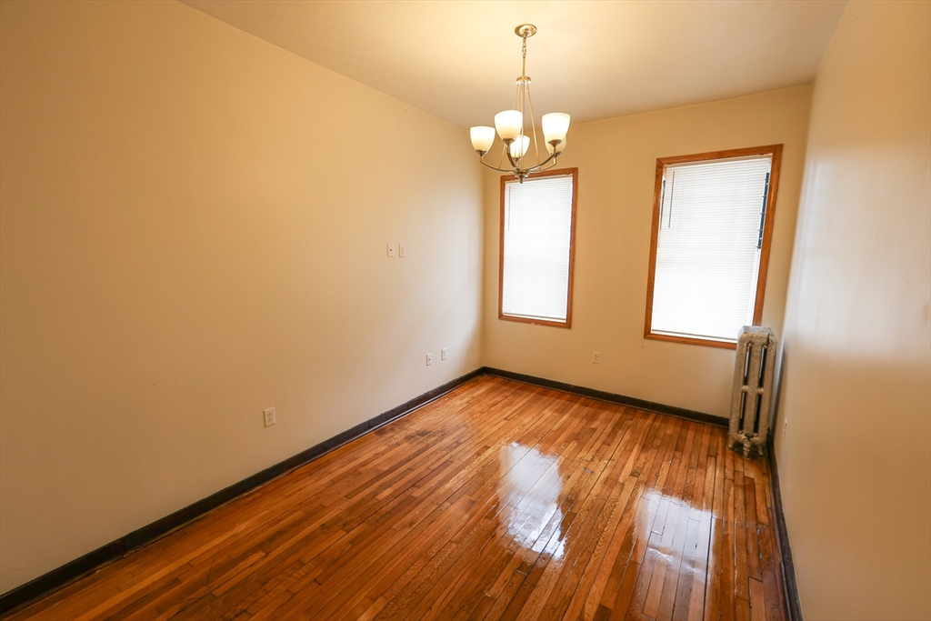 100 Seaver Street, Unit 2 Boston, MA 02121 - Photo 15 of 18 a view of an empty room with wooden floor and a window