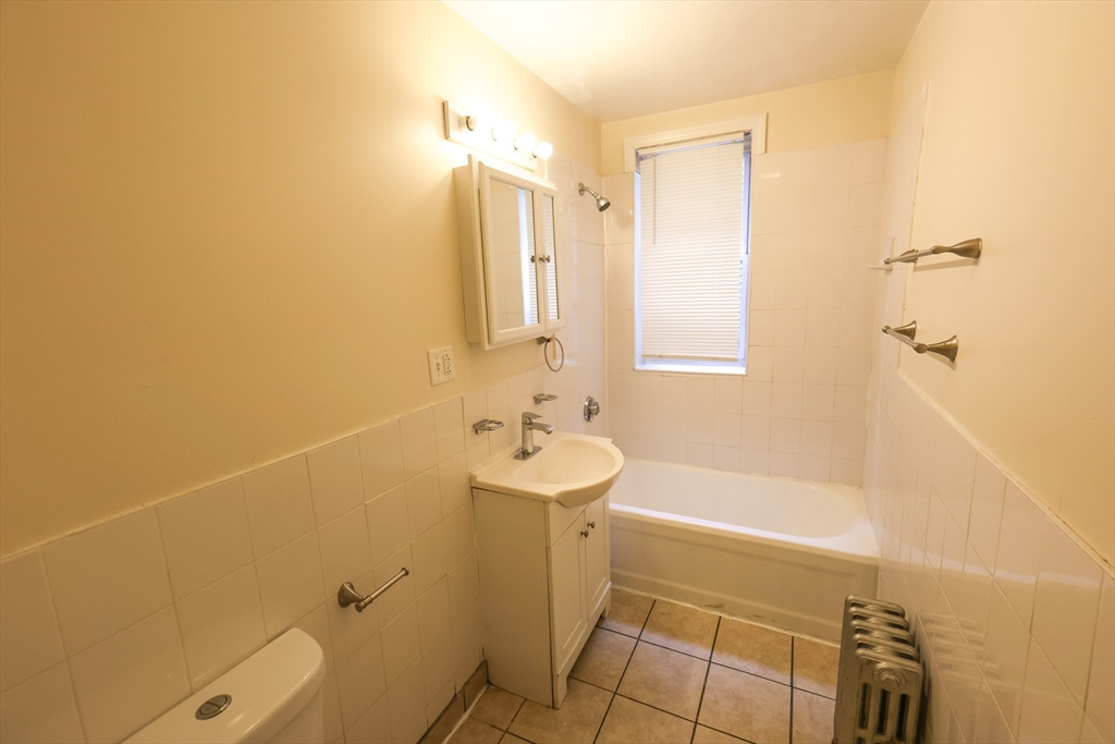 100 Seaver Street, Unit 2 Boston, MA 02121 - Photo 16 of 18 a bathroom with a sink a toilet and shower