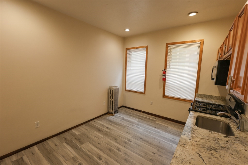 100 Seaver Street, Unit 2 Boston, MA 02121 - Photo 3 of 18 a view of an empty room with wooden floor and a window