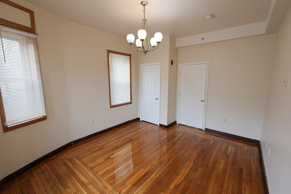 100 Seaver Street, Unit 2 Boston, MA 02121 - Photo 5 of 18 a view of an empty room with window and wooden floor