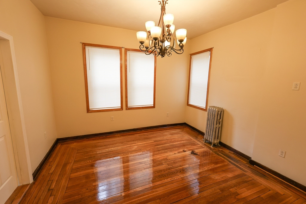 100 Seaver Street, Unit 2 Boston, MA 02121 - Photo 6 of 18 a view of a room with wooden floor and chandelier