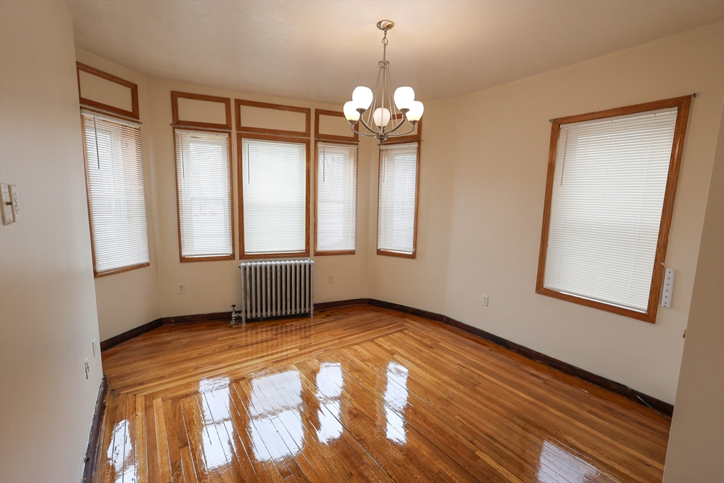 100 Seaver Street, Unit 2 Boston, MA 02121 - Photo 10 of 18 a view of an empty room with window and wooden floor