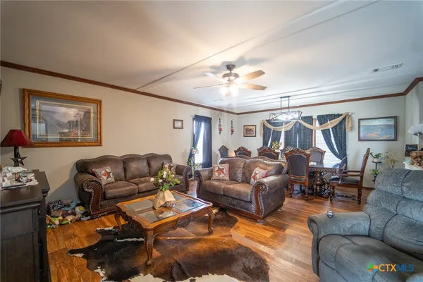 a living room with furniture ceiling fan and a rug