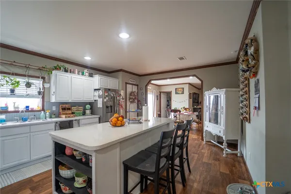 a kitchen with a table chairs and wooden floor