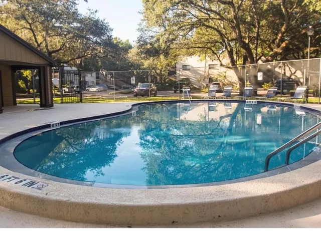 a view of swimming pool with outdoor seating and lake view