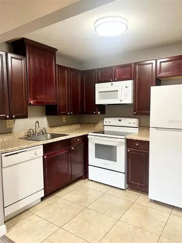 a kitchen with granite countertop a sink stainless steel appliances and cabinets