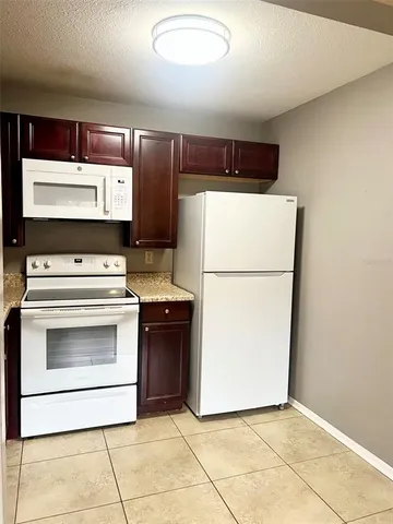 a kitchen with a stove top oven and refrigerator
