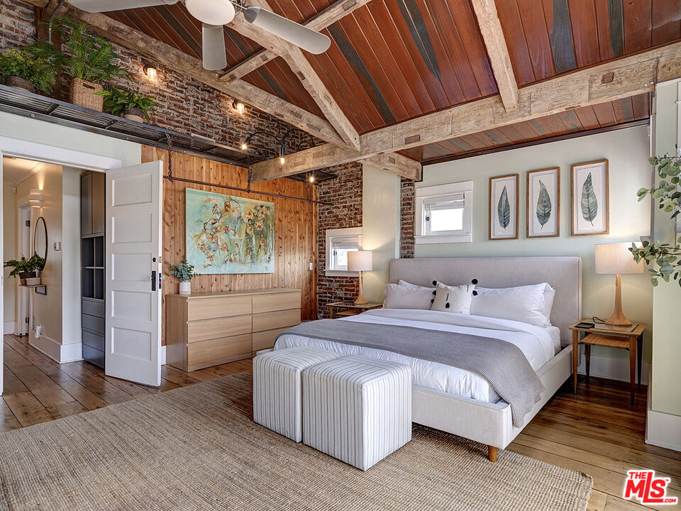 111 Dudley Avenue Venice, CA 90291 - Photo 19 of 33 a spacious bedroom with a bed a table and wooden floor