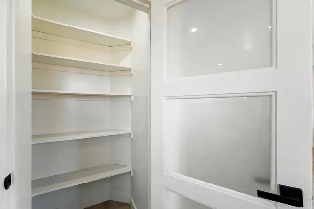 a view of walk in closet with empty racks