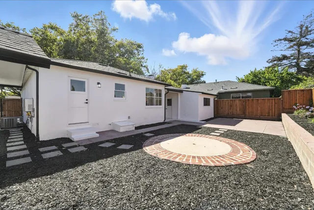 a view of a white house with a swimming pool in front of it