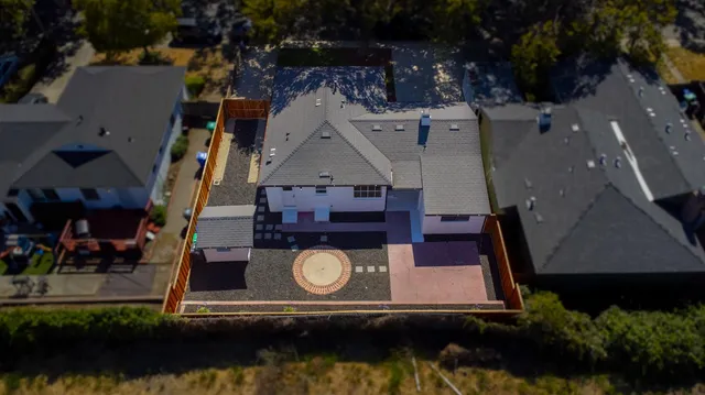 an aerial view of a house with swimming pool a yard and a patio