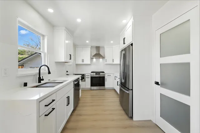 a kitchen with white cabinets and stainless steel appliances