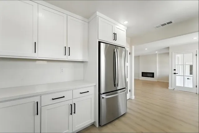 a kitchen with stainless steel appliances white cabinets and a refrigerator