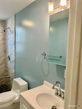 a bathroom with a toilet sink and shower
