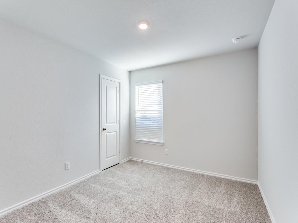 548 Bronze Circle West Springtown, TX 76082 - Photo 7 of 11 Neutral-toned carpeting with white baseboards, a white paneled door, and a single window with blinds